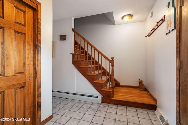 staircase with baseboard heating and tile patterned floors