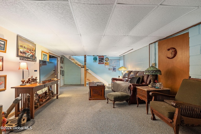 sitting room with a drop ceiling and carpet