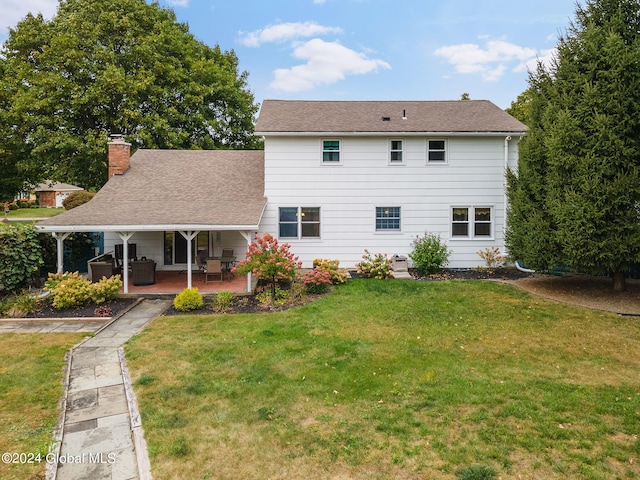 back of house featuring a patio area and a yard