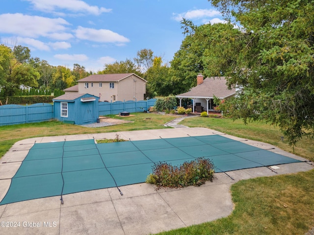 view of swimming pool featuring a patio area, a storage shed, and a lawn