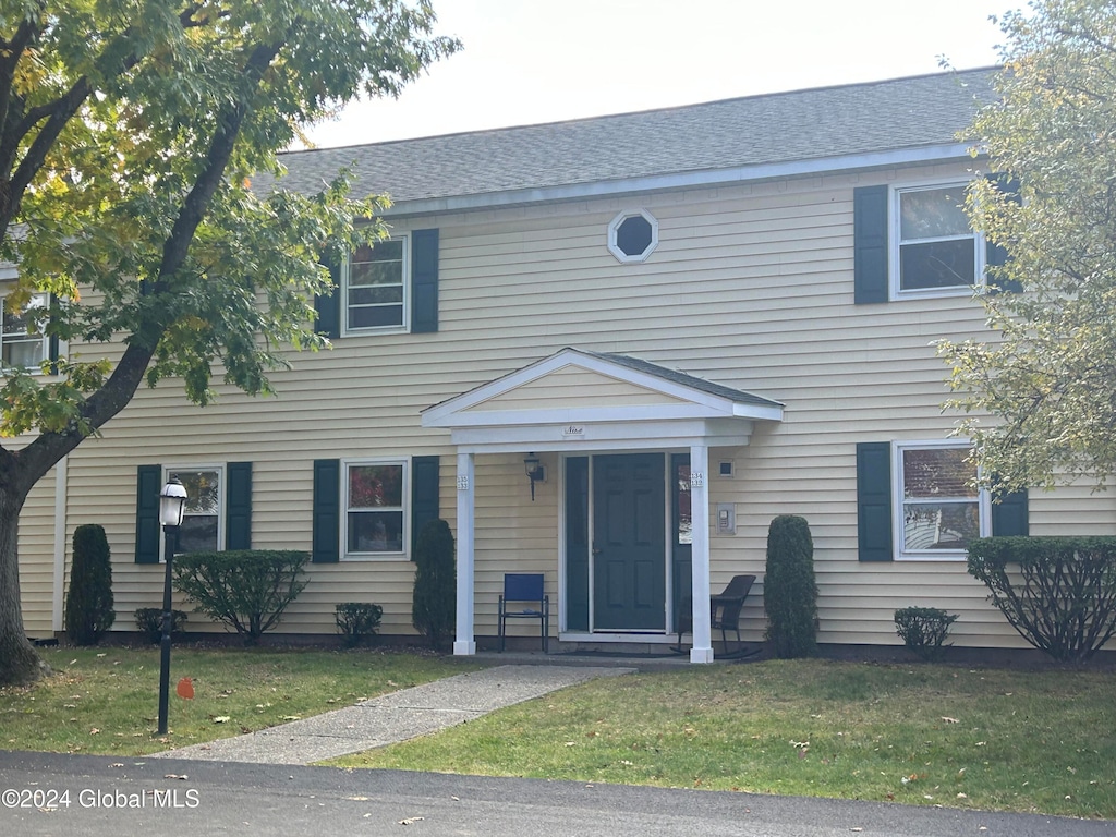 colonial home featuring a front lawn