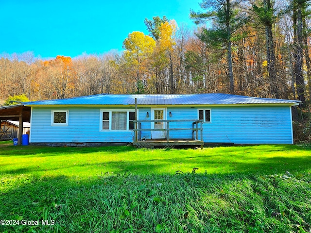 back of property with a wooden deck and a yard