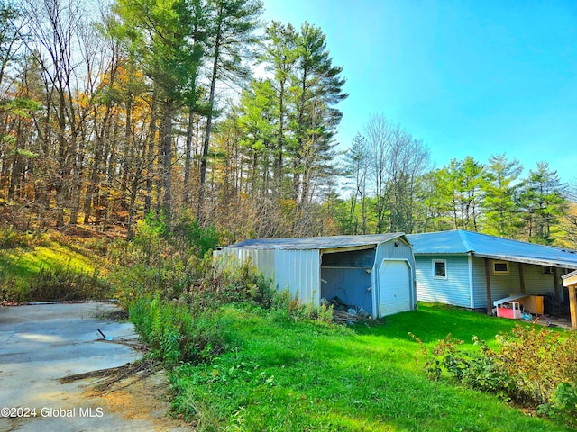 view of outdoor structure featuring a garage and a lawn