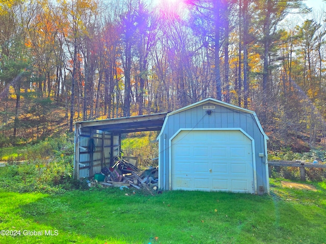 garage featuring a carport and a lawn