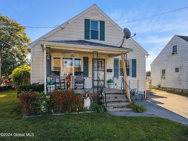 bungalow-style home featuring a porch and a front lawn