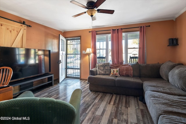 living room featuring crown molding, dark hardwood / wood-style flooring, a barn door, and ceiling fan