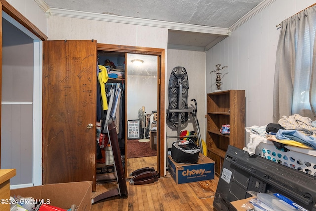 bedroom with hardwood / wood-style floors, crown molding, and wood walls