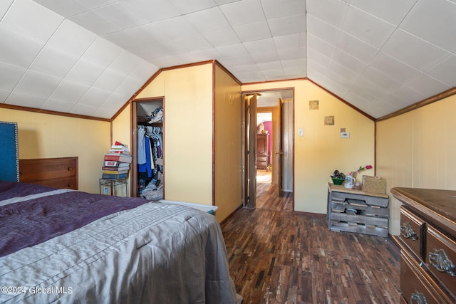 bedroom with a closet, ornamental molding, dark wood-type flooring, and lofted ceiling