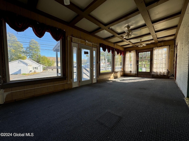 unfurnished sunroom featuring ceiling fan, coffered ceiling, and beamed ceiling