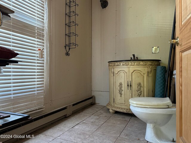 bathroom with a baseboard radiator, toilet, and tile patterned floors