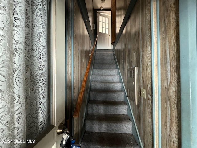 stairs featuring wooden walls