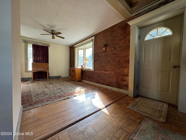 entryway featuring wood-type flooring, brick wall, and ceiling fan