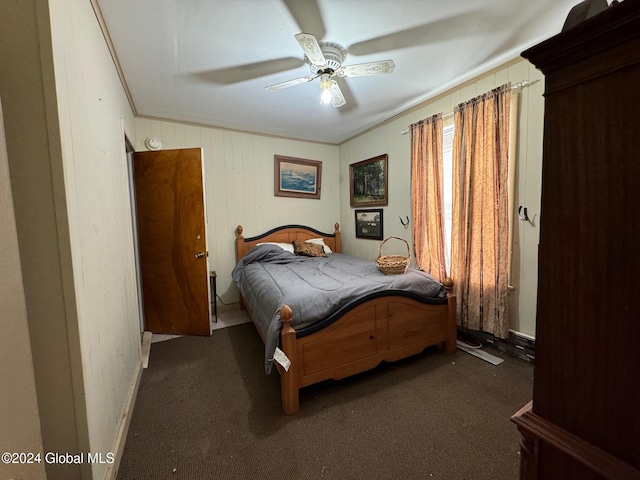 bedroom with ceiling fan, crown molding, wooden walls, and dark colored carpet