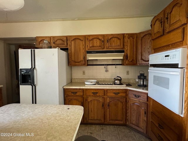 kitchen featuring tasteful backsplash and white appliances