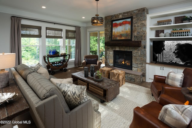 living room with a fireplace, hardwood / wood-style floors, a wealth of natural light, and ornamental molding