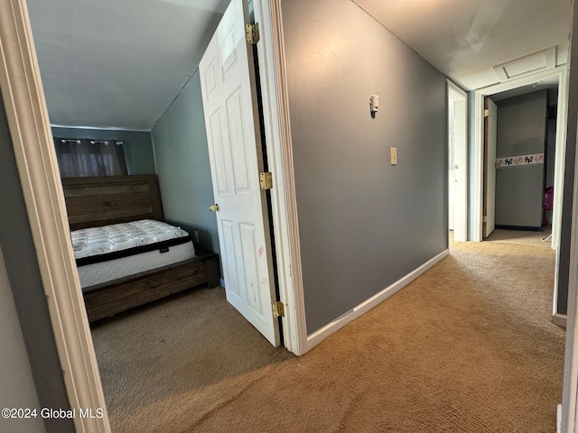 corridor featuring light carpet and vaulted ceiling