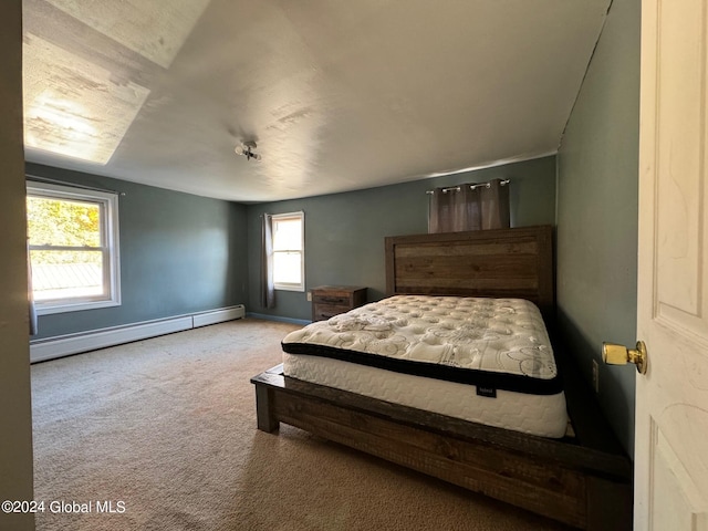 bedroom featuring baseboard heating, multiple windows, and carpet floors