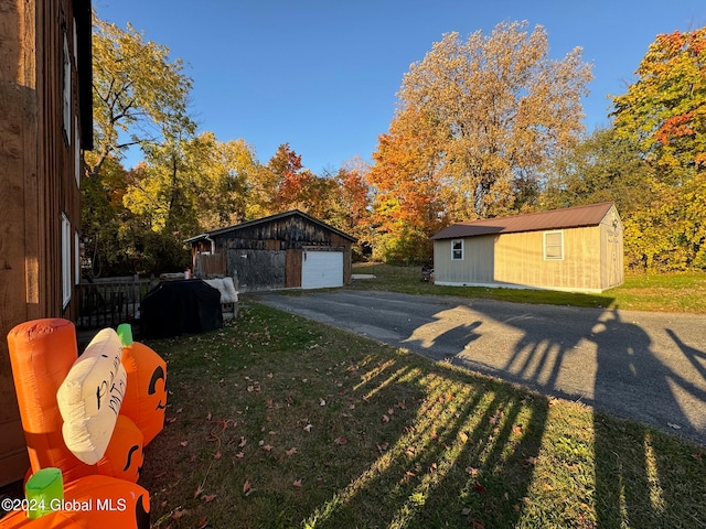 exterior space with a lawn, a garage, and an outdoor structure