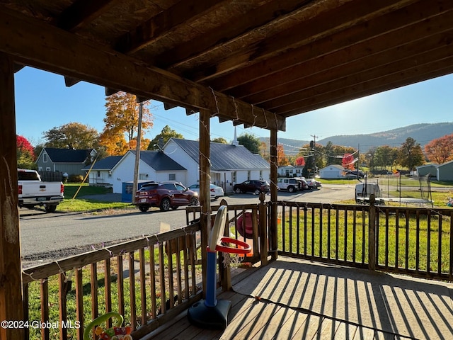 deck featuring a mountain view and a lawn