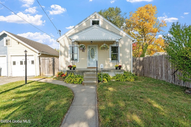 bungalow-style house with a garage and a front lawn