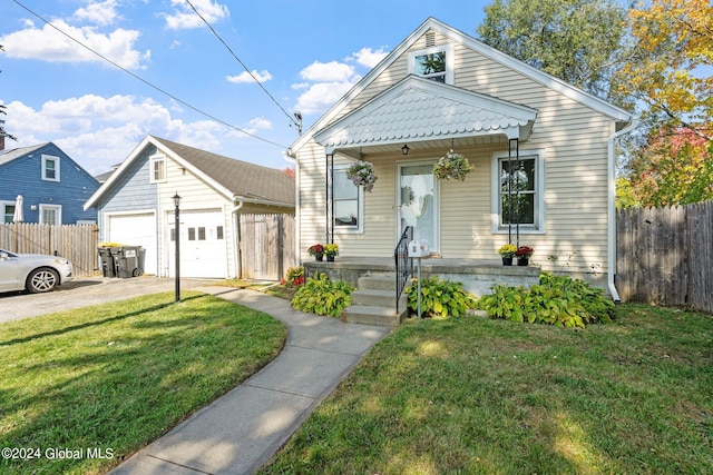 bungalow-style home featuring a front yard, a garage, covered porch, and an outbuilding