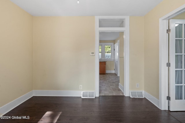 unfurnished room with dark wood-type flooring