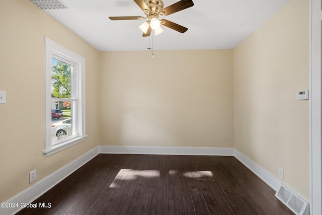 spare room featuring dark wood-type flooring and ceiling fan