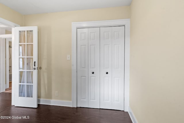 unfurnished bedroom with a closet and dark wood-type flooring