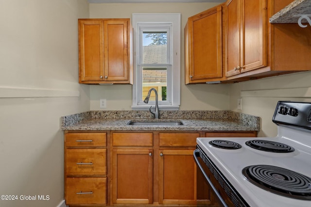 kitchen with light stone countertops, sink, and white range with electric stovetop