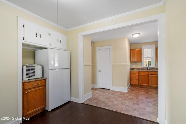 kitchen with dark hardwood / wood-style flooring, ornamental molding, light stone countertops, and white refrigerator