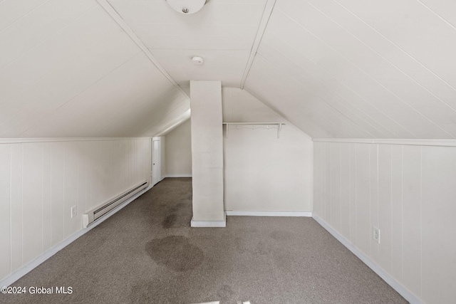 additional living space featuring baseboard heating, lofted ceiling, and dark colored carpet