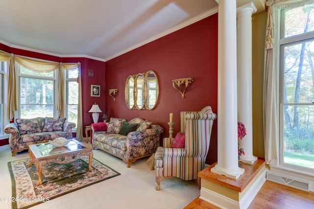 living room with crown molding, hardwood / wood-style flooring, and decorative columns