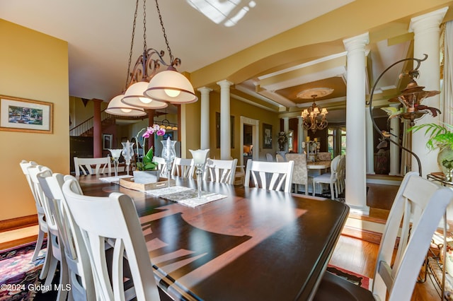 dining area featuring hardwood / wood-style flooring, a chandelier, and decorative columns