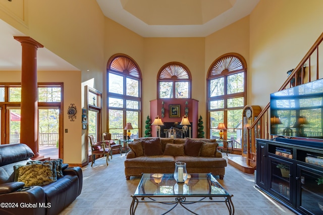 living room featuring ornate columns, carpet, and a high ceiling