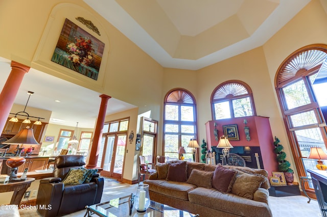 living room featuring a towering ceiling and decorative columns