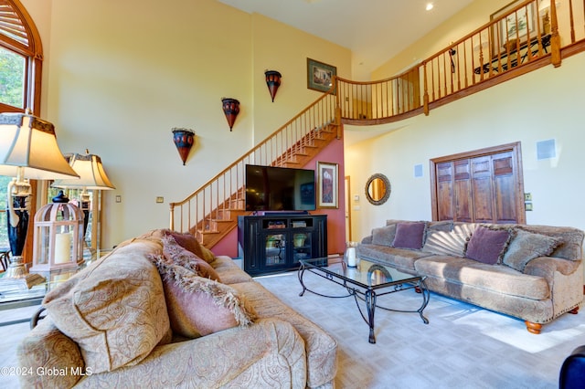 living room with a high ceiling and light colored carpet