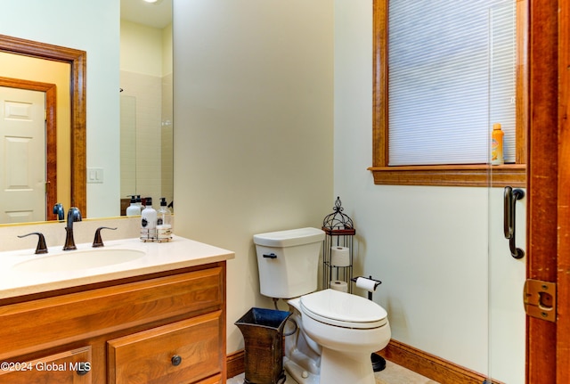 bathroom with vanity, toilet, and a shower with shower door