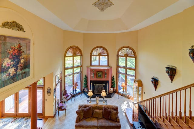 living room with a wealth of natural light, a high ceiling, and a tray ceiling