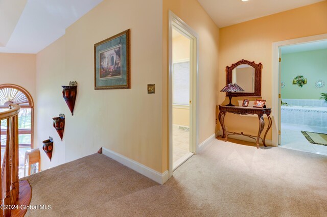 corridor featuring light colored carpet