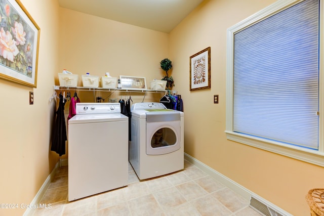 clothes washing area with light tile patterned flooring and independent washer and dryer