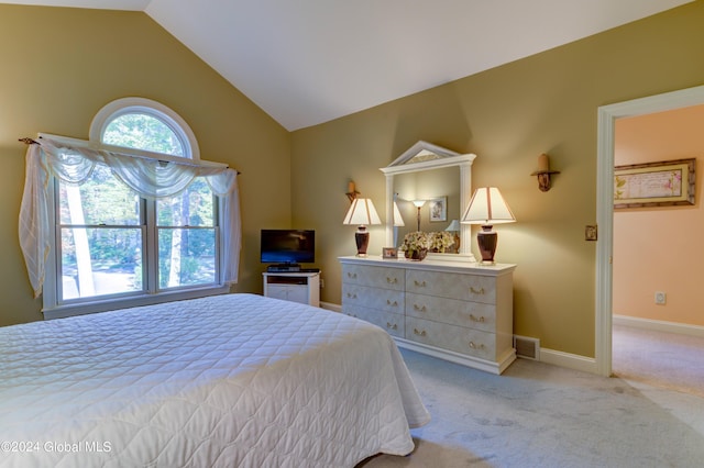 bedroom featuring light colored carpet and vaulted ceiling