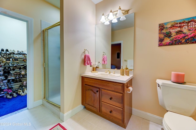 bathroom with vanity, toilet, tile patterned flooring, and an enclosed shower