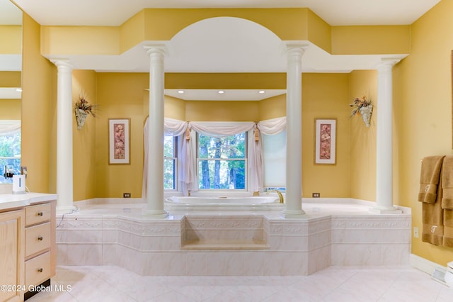 bathroom with vanity, a relaxing tiled tub, and plenty of natural light