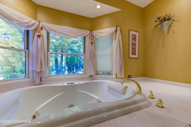 bathroom featuring a relaxing tiled tub and a wealth of natural light