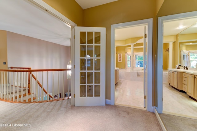 interior space with light colored carpet, sink, and ornate columns