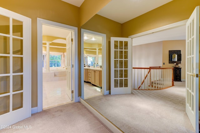 interior space featuring french doors, light carpet, and sink