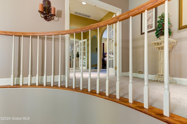 staircase featuring ornate columns and vaulted ceiling