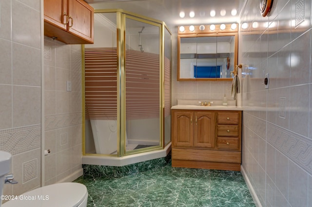 bathroom with vanity, walk in shower, toilet, and tile walls