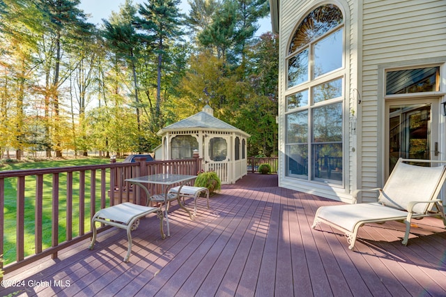 wooden terrace featuring a gazebo and a yard