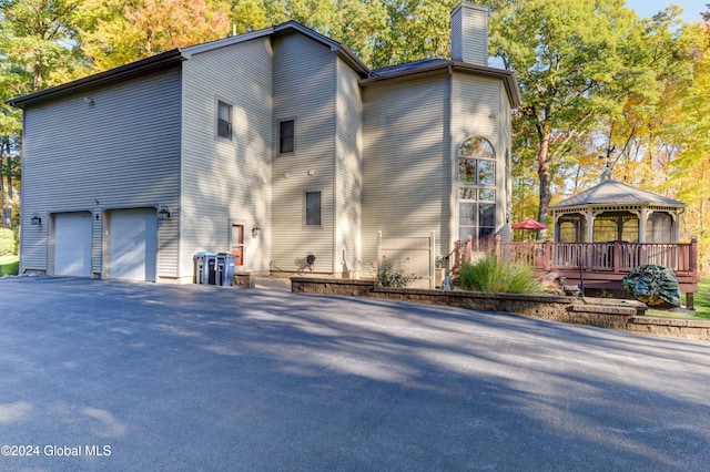 view of side of home with a gazebo and a garage